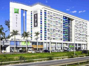 a large white building with a clock on it at ibis Styles Confins Aeroporto in Lagoa Santa