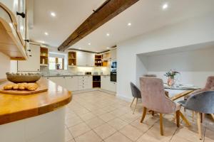 a kitchen with white cabinets and a table and chairs at 6 Bed in Machynlleth oc-bow374 in Cemmaes