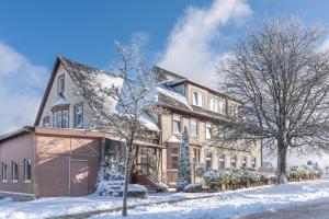 a large house with snow on the ground at Pension Haus Saarland in Oberhof