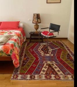 a bedroom with a bed and a chair and a rug at Alexis 1 in Novara