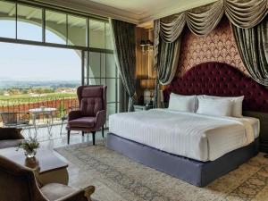 a bedroom with a large bed and a chair at Mövenpick Resort Khao Yai in Ban Wang Sai