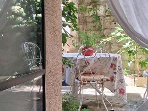 a table and a chair on a balcony with a table and a table and chairs at Chambre d'hôte Maison Magda in Beaucaire +28 photos