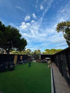 a large yard with green grass on a building at Surf Camp Ecológico in Costa da Caparica