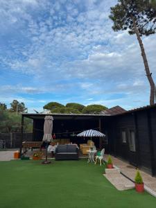 a backyard with a green lawn and a house at Surf Camp Ecológico in Costa da Caparica