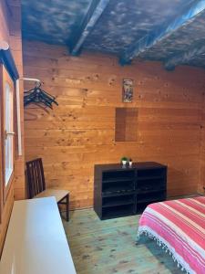 a bedroom with wooden walls and a bed and a dresser at Surf Camp Ecológico in Costa da Caparica