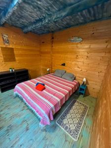 a bedroom with a bed in a wooden room at Surf Camp Ecológico in Costa da Caparica