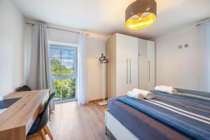 a room with a bed and a desk and a window at Haus Burgblick in Badenweiler