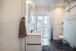 a white bathroom with a sink and a toilet at Haus Burgblick in Badenweiler +48 photos
