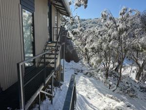 a balcony of a house with snow on the ground at Tanjil Creek Lodge in Baw Baw Village