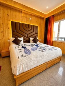 a bedroom with a large bed with a wooden wall at The Amber Retreat - Best Property In Mussoorie #Luxury Rooms #Balcony #Parking #Budget Friendly #Mountain View #Restaurant #Couple Friendly in Mussoorie