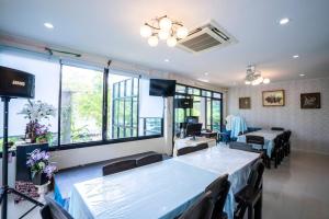 a dining room with tables and chairs and windows at Phangpring Beach Resort in Ban Phang Pling