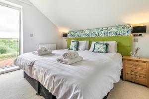 a bedroom with a large bed with towels on it at 4 Bed in Winnards Perch oc-t29558 in Saint Columb Major +29 photos