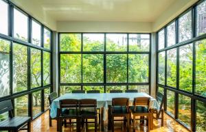 a dining room with a table and chairs and windows at Phangpring Beach Resort in Ban Phang Pling