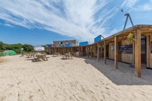 a group of picnic tables in the sand in front of a building at 4 Bed in Winnards Perch oc-t29558 in Saint Columb Major