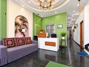 a lobby with a couch and green walls at Shree Radha Vallabh Palace 800 m from Prem Mandir in Vrindāvan