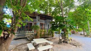 a picnic table in front of a building with trees at Phangpring Beach Resort in Ban Phang Pling