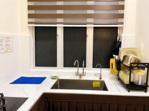 a kitchen with a sink and two windows at iHomie Suites - 4Bedroom Homestay Kulim in Kulim +11 photos