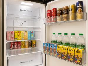 an open refrigerator filled with drinks and soda at iHomie Suites - 4Bedroom Homestay Kulim in Kulim