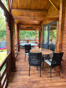 a wooden deck with a table and chairs on it at Relax nad Narwią u Oli Pawła in Chmielewo