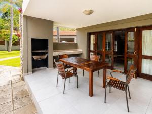 a patio with a wooden table and chairs at Giney's View 8 Unit in Vilanculos