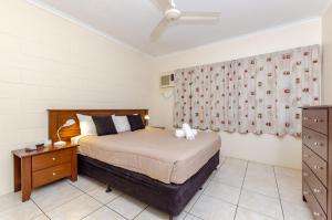 a bedroom with a bed and a table and a curtain at Como Apartments Gladstone in Gladstone