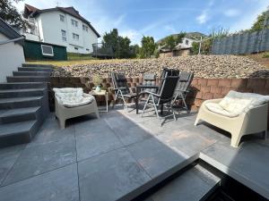 a patio with chairs and tables and a brick wall at Arche Otto in Marienheide