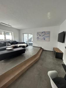 a living room with a black couch and a table at Arche Otto in Marienheide