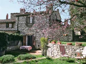 an old stone house with a table and chairs in the yard at La finestra sul Chianti in Radda in Chianti