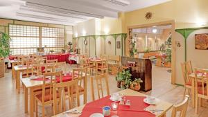 a restaurant with wooden tables and chairs and a cafeteria at Pension Haus Saarland in Oberhof +17 photos