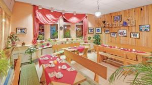 a restaurant with tables and benches in a room at Pension Haus Saarland in Oberhof