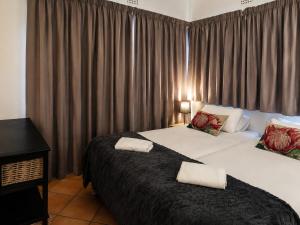 a bedroom with two beds and a window with curtains at Anna Boeremeisie Guesthouse in Benoni +65 photos