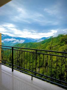 a balcony with a view of a mountain at The Amber Retreat - Best Property In Mussoorie #Luxury Rooms #Balcony #Parking #Budget Friendly #Mountain View #Restaurant #Couple Friendly in Mussoorie