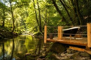 a bath tub sitting on a wooden bridge next to a river at Villa Boutique 1880-Romantic Historic Boutique Hotel with Outdoor Jacuzzi in San Salvador
