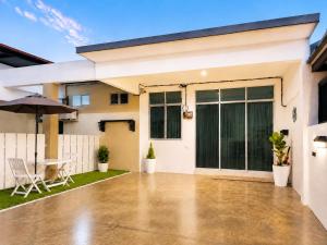 a house with a patio with an umbrella at iHomie Suites - 4Bedroom Homestay Kulim in Kulim