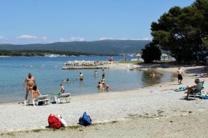 a group of people swimming in the water at a beach at Rooms with a parking space Krk - 5371 in Krk +6 photos