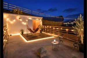 a patio with a hammock and a bench at night at Guest House-空- in Takamatsu
