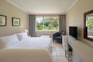 a hotel room with a bed and a television at Protea Hotel by Marriott Chingola in Chingola