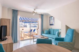 a living room with a blue couch and a table at Ona Los Claveles in Los Cristianos