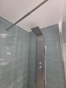a shower in a bathroom with blue tiles at Danube Exclusiv in Calafat
