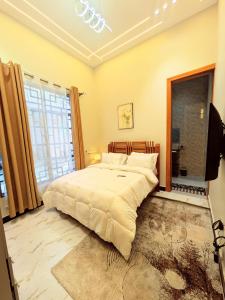 a bedroom with a large bed and a large window at R&E Apartments in Dodoma