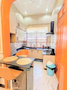 a large kitchen with a table and chairs at R&E Apartments in Dodoma