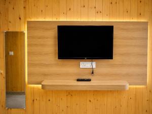 a flat screen tv on a wall with acision at The Amber Retreat - Best Property In Mussoorie #Luxury Rooms #Balcony #Parking #Budget Friendly #Mountain View #Restaurant #Couple Friendly in Mussoorie