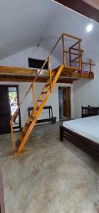 a bedroom with a wooden bunk bed and a staircase at Eco Palms in Pottuvil