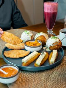 a plate of food with pastries and dips on a table at Suite de Lujo Piscina Hidromasaje in Quito