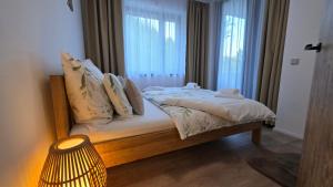 a bedroom with a bed with a window and a lamp at Apartmán Mlýn 208 in Vrchlabí