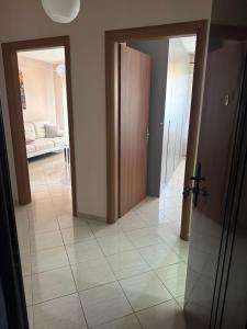 a hallway with two open doors and a living room at Kodra Apartament in Golem