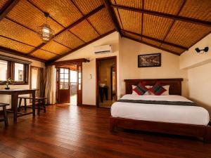 a bedroom with a bed and a table in it at Sola Hoi An in Thanh Ðông (1)