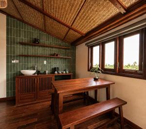 a kitchen with a wooden table and two benches at Sola Hoi An in Thanh Ðông (1)