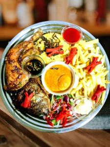 a plate of food with meat and fries and sauce at MIAMi VILLA HOTEL in Mpanda