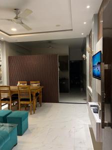 a dining room with a table and a television at Couple friendly spacious 1BHK in Indore